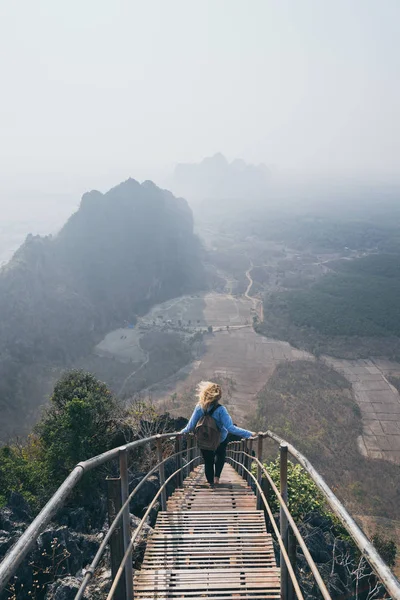 Kvinna stående på bergstopp med trappor går ner under Sunrise Dimmig morgon i hPa-an, Myanmar — Stockfoto