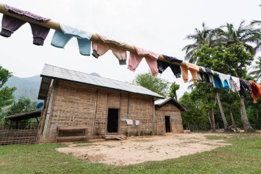 Nong Khiaw, Laos yakınlarındaki bir köyde geleneksel Laos bambu kulübenin önünde taze çamaşır kurutma