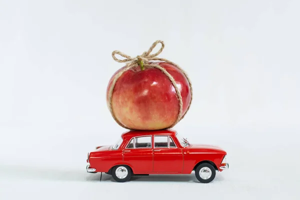Coche de juguete rojo con manzana roja en el techo —  Fotos de Stock