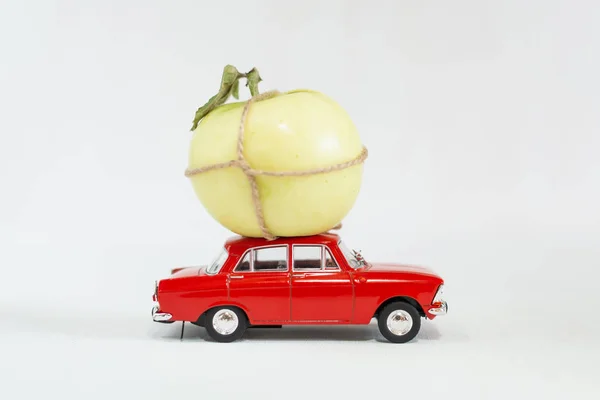 Coche de juguete rojo con manzana verde en el techo —  Fotos de Stock