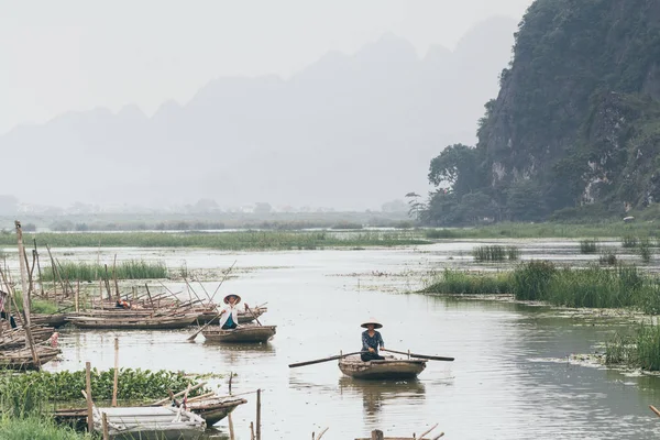 ニンビン、ベトナム - 2019年5月:トラン・アン自然公園を通過する木製の手漕ぎボートに乗ったベトナム人女性 — ストック写真
