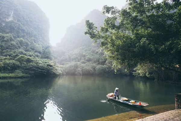 ニンビン、ベトナム - 2019年5月:トラン・アン自然公園を通過する木製の手漕ぎボートに乗ったベトナム人女性 — ストック写真
