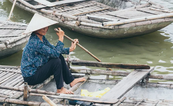 Ninh Binh, Vietnam - Mayo 2019: Mujer vietnamita en un bote de remos de madera atravesando el parque natural Trang An —  Fotos de Stock