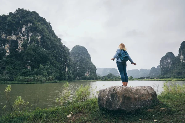Blanke blonde vrouw met uitzicht op kalkstenen bergen in de provincie Ninh Binh, Vietnam — Stockfoto