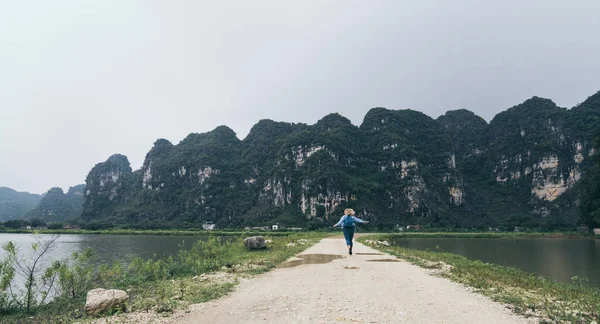 베트남 닌빈 지방의 석회암 산맥을 향해 달리는 백인 금발 의여성 — 스톡 사진