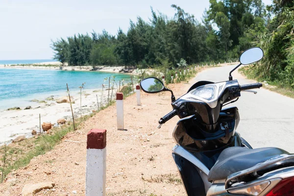 Motorcycle standing on sea shore on the way to Hai Van pass, Vietnam
