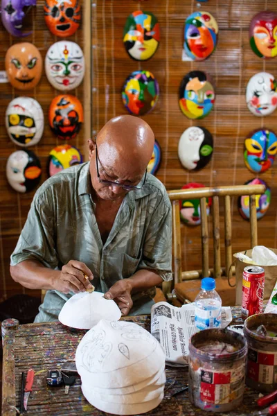 Hoi An, Vietnam - Haziran 2019: atölyesinde geleneksel Vietnam maskelerini boyayen adam