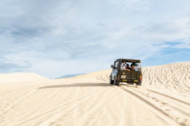 Mui Ne, Vietnam - Haziran 2019: gün doğumunda çöl kumtepelerinde giden off-road vintage sovyet arabası