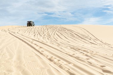 Mui Ne, Vietnam - Haziran 2019: gün doğumunda çöl kumtepelerinde giden off-road vintage sovyet arabası