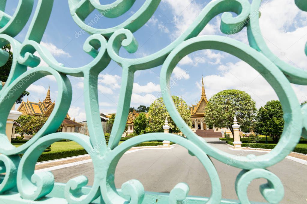 View over Phnom Penh Royal Palace through the iron entrance gate on sunny day, Cambodia