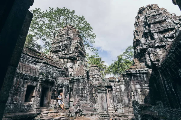 Кавказька людина з камерою стоїть серед руїн храмового комплексу Ангкор-Ват у місті Сіємреап, Камбоджа — стокове фото