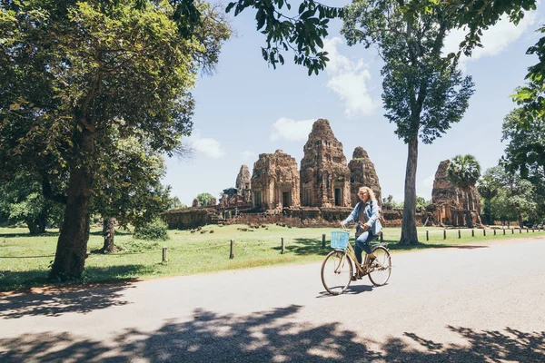 Young woman riding bike next to Pre Rup temple in Angkor Wat complex, Cambodge — Photo