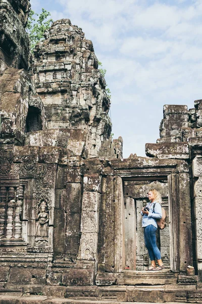 Caucasian blonde woman discovering the ruins of Angkor Wat temple complex in Siem Reap, Cambodia — Stock Photo, Image