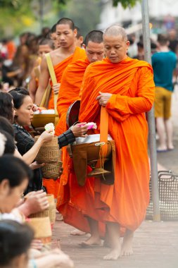 Luang Prabang, Laos - Mayıs 2019: Laoslular sadaka töreni sırasında Budist rahiplere adaklar yapıyor