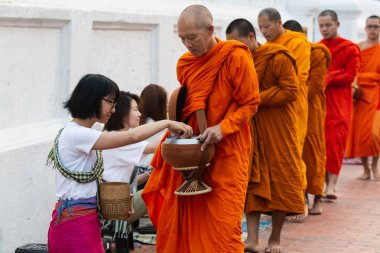 Luang Prabang, Laos - Mayıs 2019: Laoslular sadaka töreni sırasında Budist rahiplere adaklar yapıyor