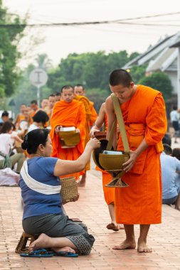 Luang Prabang, Laos - Mayıs 2019: Laoslular sadaka töreni sırasında Budist rahiplere adaklar yapıyor