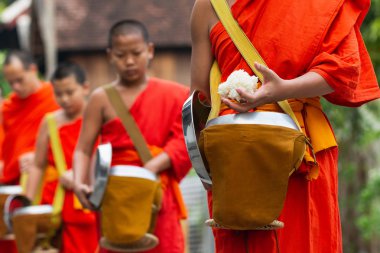 Luang Prabang, Laos - Mayıs 2019: Laoslu Budist rahipler sadaka töreni sırasında sokakta yürürken