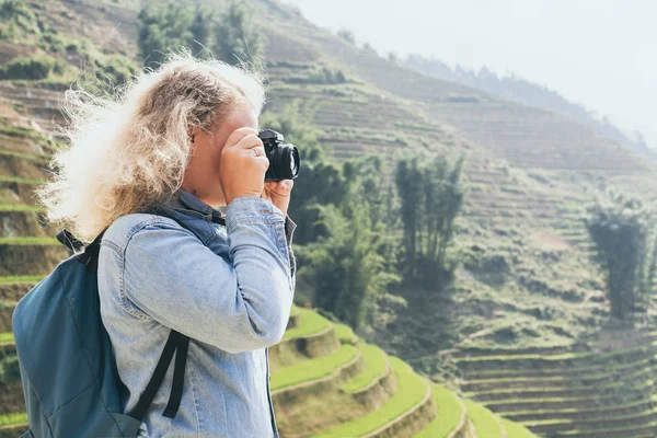 Jonge Kaukasische blonde vrouw in denim shirt Foto's maken van Sapa rijstterrassen bij zonsondergang in Lao Cai Province, Vietnam — Stockfoto