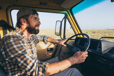 Doğu Avrupalı genç bir adam kırsal bölgede sarı bir karavanla seyahat ediyor. Otomatik inşa edilmiş karavan, vahşi doğada kamp yapıyor..