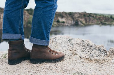 Dişi deri botlar kayalık dağda duruyor.