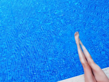 Bacaklar havuza. Yaz tatilinde.