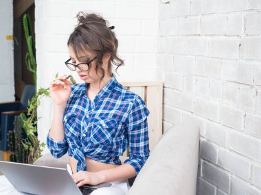 kadın kanepede oturan çalışıyor. El cep telefonu tutan ve bir defter ile çalışma.