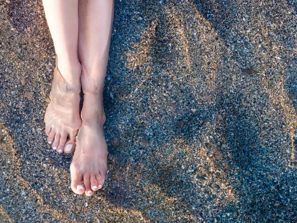 Pernas de mulher na praia de areia — Fotografia de Stock