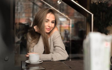 gülen genç kadın bir kafede. Kahve içmek ve dreamig