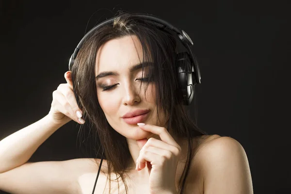 Jeune belle femme écoutant de la musique sur écouteurs — Photo