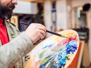 Ressam sanatçı closeup mix boyalar ve modern bir soyut yağlıboya stüdyosunda çalışma.