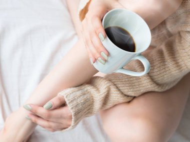 Erkek fotoğrafı bacaklar ve rahatlatıcı ve içme kahve yatakta eller.