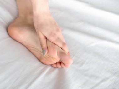 Genç kadın bacağı yatakta dokunmadan