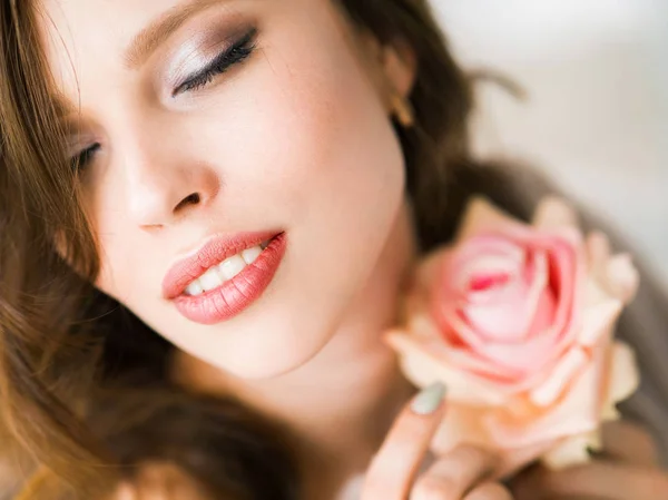 Близкий портрет красивой молодой женщины в постели с розой — стоковое фото
