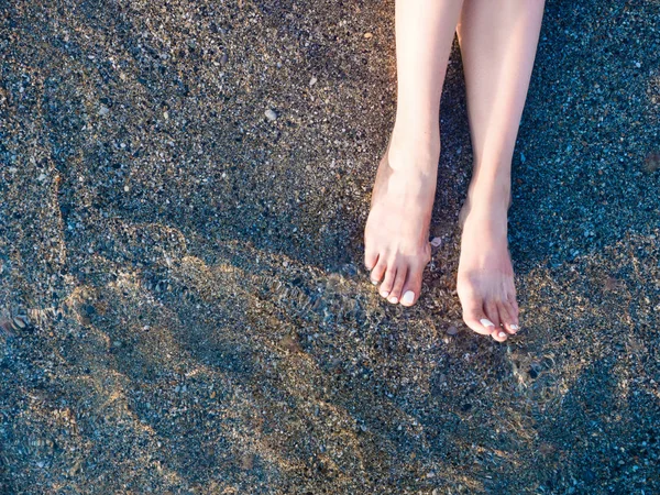 俯瞰大海的沙滩上的女性脚放松 — 图库照片