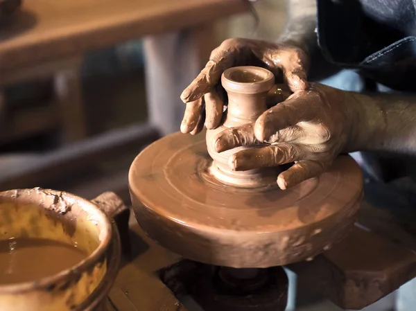 Potterovy ruce mají tvar hrnku z hlíny. Proces vytváření keramiky na hrnčířském kole. Mistr keramiky pracuje ve svém studiu. Detailní záběr, jen ruce. Nádobí z hliněných vlastních rukou. — Stock fotografie