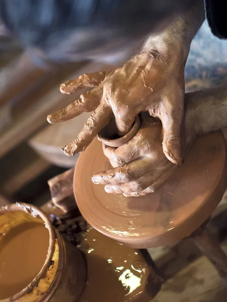 As mãos de oleiros dão forma a um copo de um barro. O processo de criação de cerâmica em uma roda de oleiros. O mestre ceramista trabalha em seu estúdio. Close-up, só mãos. Louça de barro próprias mãos. — Fotografia de Stock