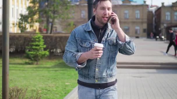 Homem Roupas Casuais Caminha Pela Rua Fala Telefone Durante Uma — Vídeo de Stock