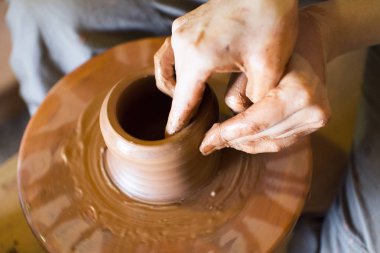 Potters dönen tekerlek ve kil eşya üstünde o vazo: yukarıdan çekilmiş. Kil elinde. Çömlekçilik: erkek ustası bir el yapımı kil ürün oluşturur. Potters tekerlek, ustası elinde dönme işlemi.