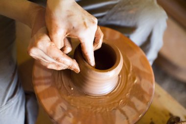 Potters dönen tekerlek ve kil eşya üstünde o vazo: yukarıdan çekilmiş. Kil elinde. Çömlekçilik: erkek ustası bir el yapımı kil ürün oluşturur. Potters tekerlek, ustası elinde dönme işlemi.