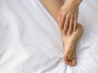 Genç kadın yatak., sağlık kavramı ayağına masaj