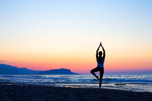 Silhueta Ásia mulher ioga na praia ao pôr do sol — Fotografia de Stock