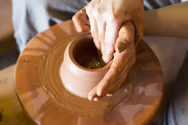 Otáčení kola a hliněné nádobí na něm keramiky váza: převzaty z výše. Ruce do hlíny. Keramika: mužské keramik vytváří ručně vyráběné hliněné produktu. Proces otáčení hrnčíři kola, ruce keramik. — Stock fotografie