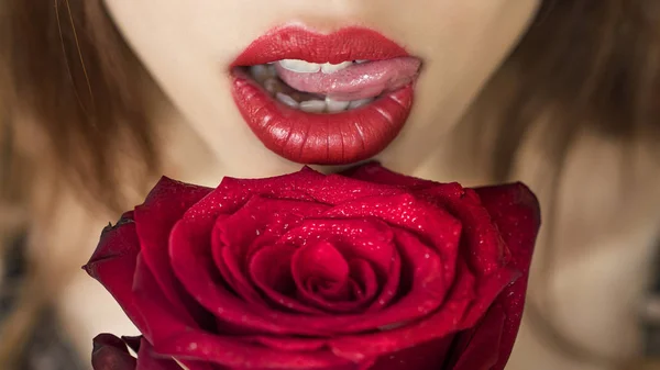 Close-up shot van sexy vrouw lippen met rode lippenstift en mooie rode rose — Stockfoto