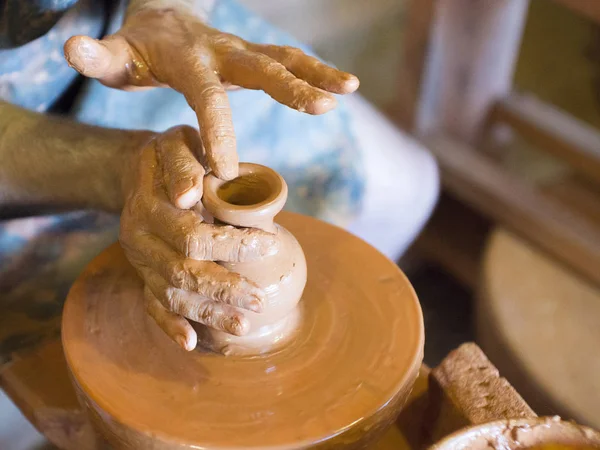 Roue de potiers rotatifs et ustensiles d'argile sur elle vase : prise d'en haut. Les mains dans l'argile. Poterie : céramiste masculin crée un produit en argile fait main. Processus de rotation de la roue des potiers, les mains du céramiste — Photo