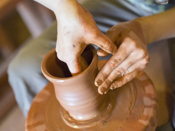 Hands of a potter, creating an earthen jar on the circle — Stock Photo, Image