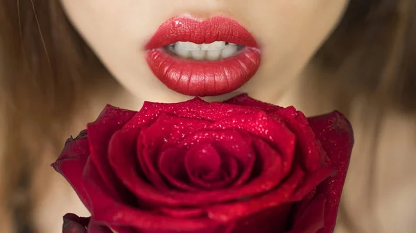 Close-up tiro de lábios mulher sexy com batom vermelho e bela rosa vermelha — Fotografia de Stock