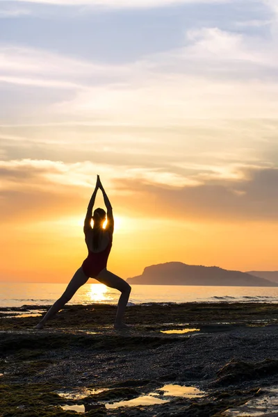 Meditação menina no mar durante o pôr do sol. Sílhueta de ioga. Fitness e estilo de vida saudável. — Fotografia de Stock