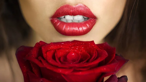 Close-up shot van sexy vrouw lippen met rode lippenstift en mooie rode rose — Stockfoto