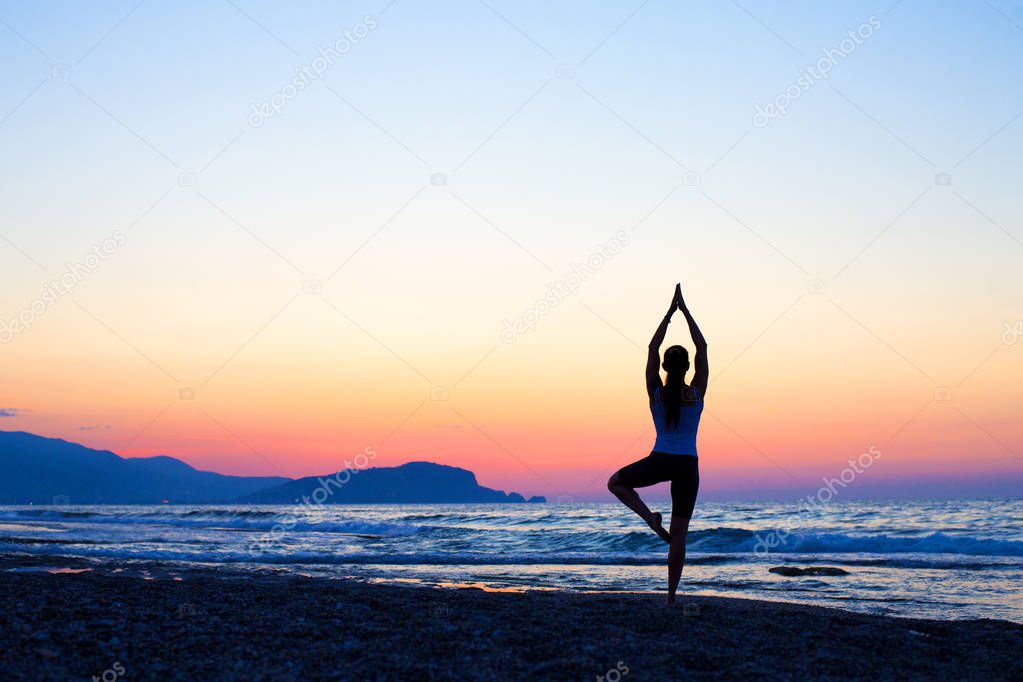 Silhouette Asia woman yoga on the beach at sunset