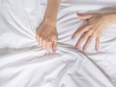 Eller kadınların şehvet ve orgazm beyaz çarşaf çekerek.